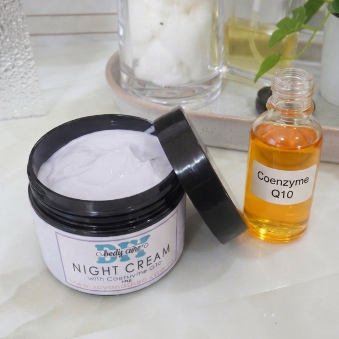 A black jar with a decorative product label identifying it as Night Cream, sits on a marble bathroom counter top. The lid is removed and rests against the side of the jar revealing a lilac cream. By the pot is a clear glass bottle with an orange liquid and is labelled Coenzyme Q10