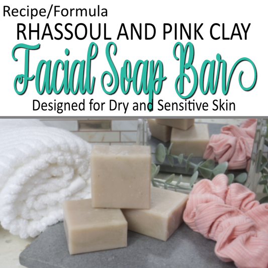 A cover photo indicating this is a formula for Facial soap bars with rhassoul and pink clay.   Along with the text, there is a photo of a selection of small, square soap bars on a grey surface surrounded by a towel, scrunchie, mirror and greenery.