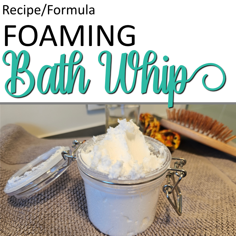 A product cover photo with the text BATH WHIP in teal cursive writing in the top half of the image against a white background.  The bottom half has an image of a clear jar filled with a white soft but solid cream standing on a brown towel with a brush and scrunchie in the background.
