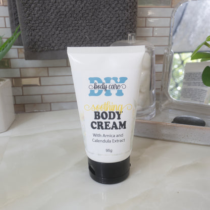 A white tube with black cap stands on a bathroom countertop and is labelled as Soothing Body Cream with arnica and calendula Extract.